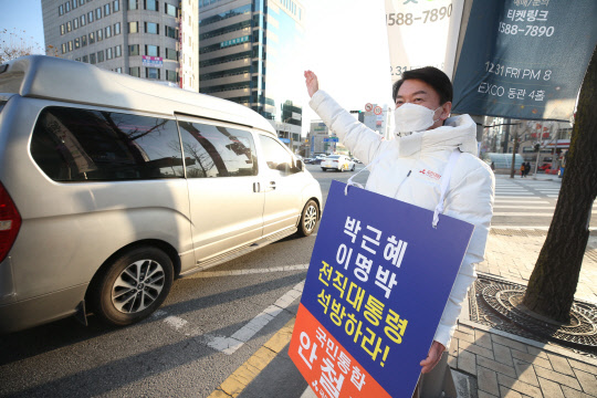 20일 국민의당 안철수 대선 후보가 대구 중구 지하철 2호선 경대병원역 인근에서 이명박·박근혜 전 대통령의 석방을 촉구하는 피켓을 들고 출근길 시민에게 인사하고 있다. 연합뉴스.